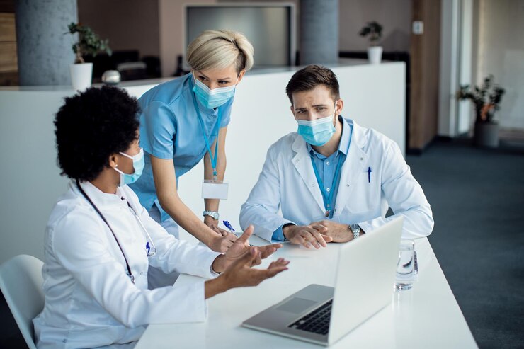 Group Medical experts talking while using laptop