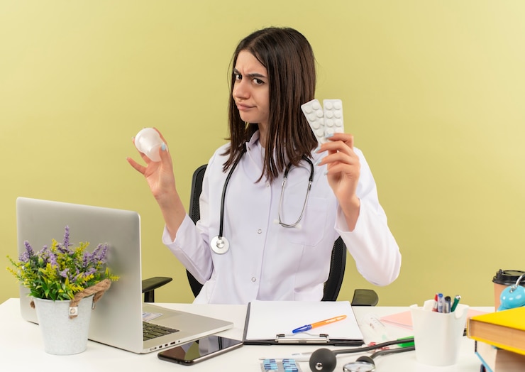 Young feamle doctor with white coat with stethoscope holding a test jar